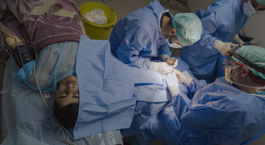 Still from American Doctor: a view from above of a surgical team operating on a patient under blue drapes.