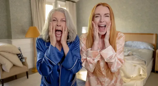 Still from Freakier Friday: two women in pyjamas, one with grey hair and one with long reddish hair, put their hands to their faces in shock in a bedroom.