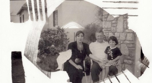 Still from My Father and Qaddafi: a faded photograph of a family sitting together outdoors, framed by a torn white edge.