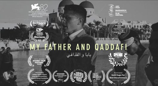 Poster for My Father and Qaddafi: the title in white text and a row of festival laurels over a black-and-white photograph of a man at a microphone.