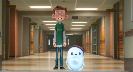Still from Ron's Gone Wrong: an animated boy stands in a school corridor with a small white robot beside him.