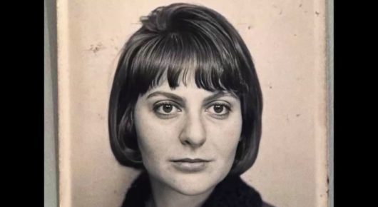 Still from Tricontinental: a black-and-white portrait of a woman with a dark bob and a straight fringe.