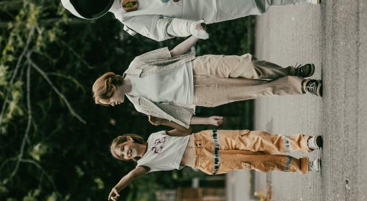 Still from Uncle Artoo: a group of people in white tops walk along a path beside trees.